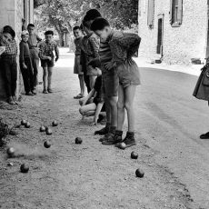 La petite fille regarde les garçons jouer à la pétanque