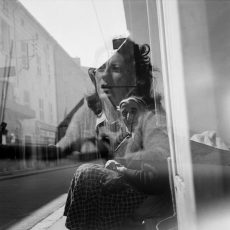 Vieille femme dans la rue. Reflets jeune femme dans une vitrine